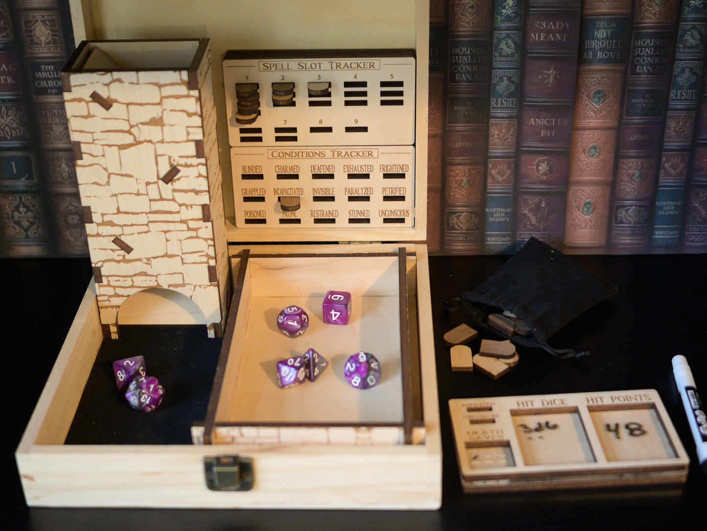 Wooden dice storage box with purple dice and game accessories on a shelf with books in the background.
